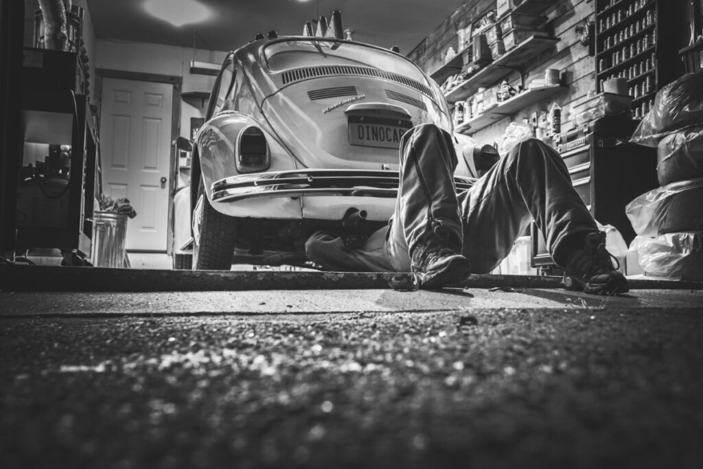 Guy working on a VW bug in his garage