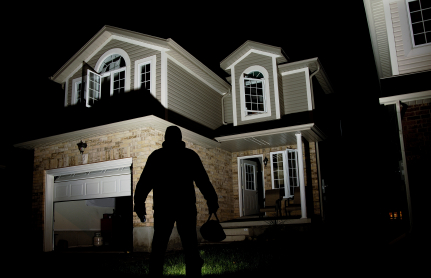 A thief in front of a home at night